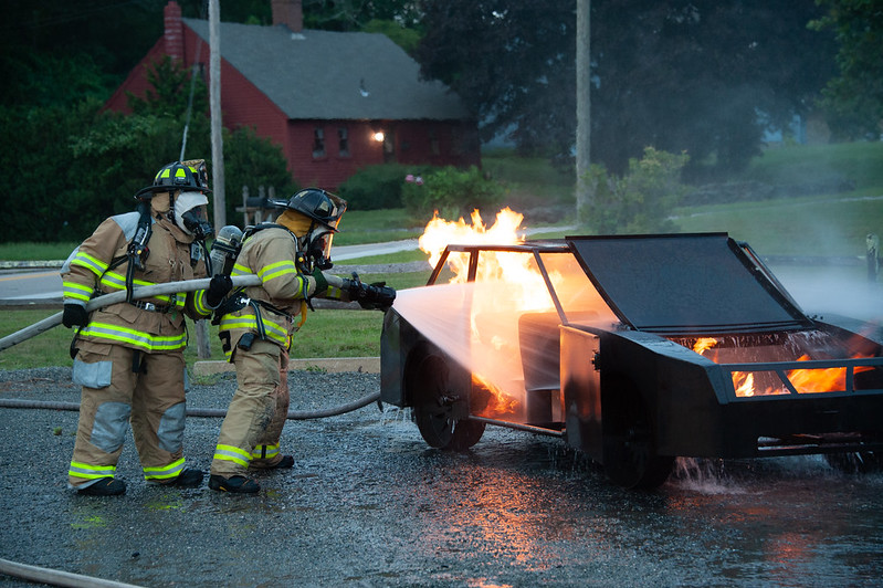 Myself on the nozzle with my wife backing me up, training on extinguishing a car fire prop during a drill with the fire department.